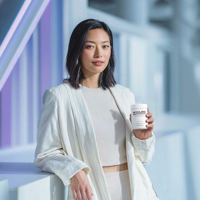 Woman holding Codeage Methylated Multivitamin+ with a blurred background