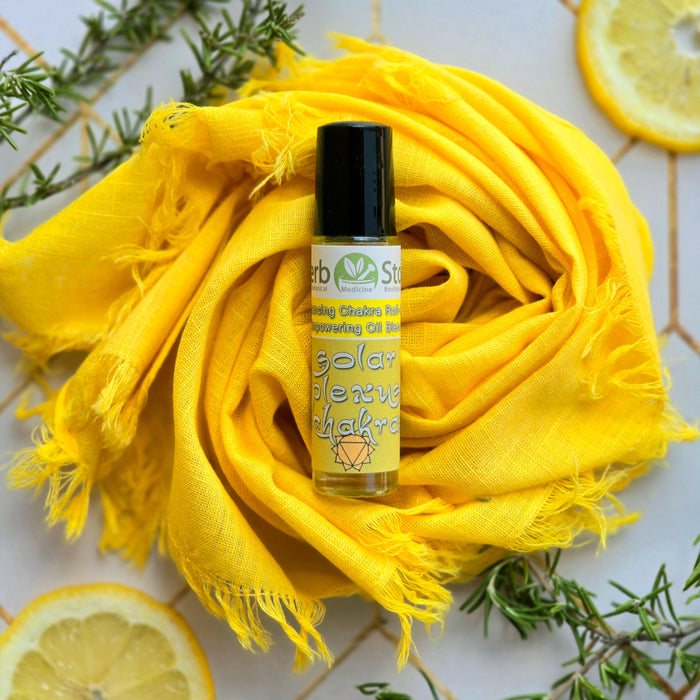Solar Plexus Chakra Roll-On on a yellow cloth with rosemary and lemon